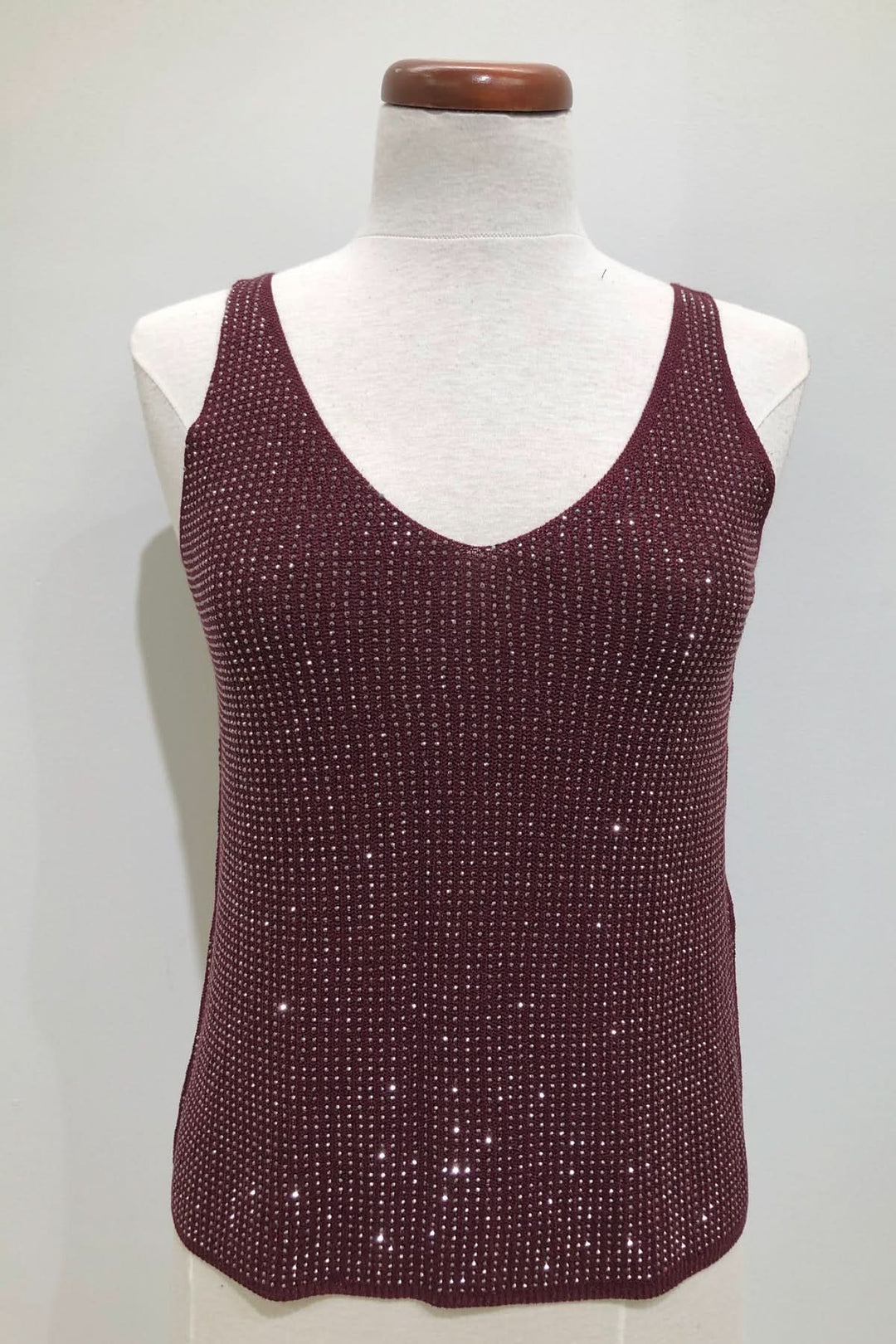 Camisole en V scintillante bordeaux avec texture tricotée et brillance discrète pour un look élégant.