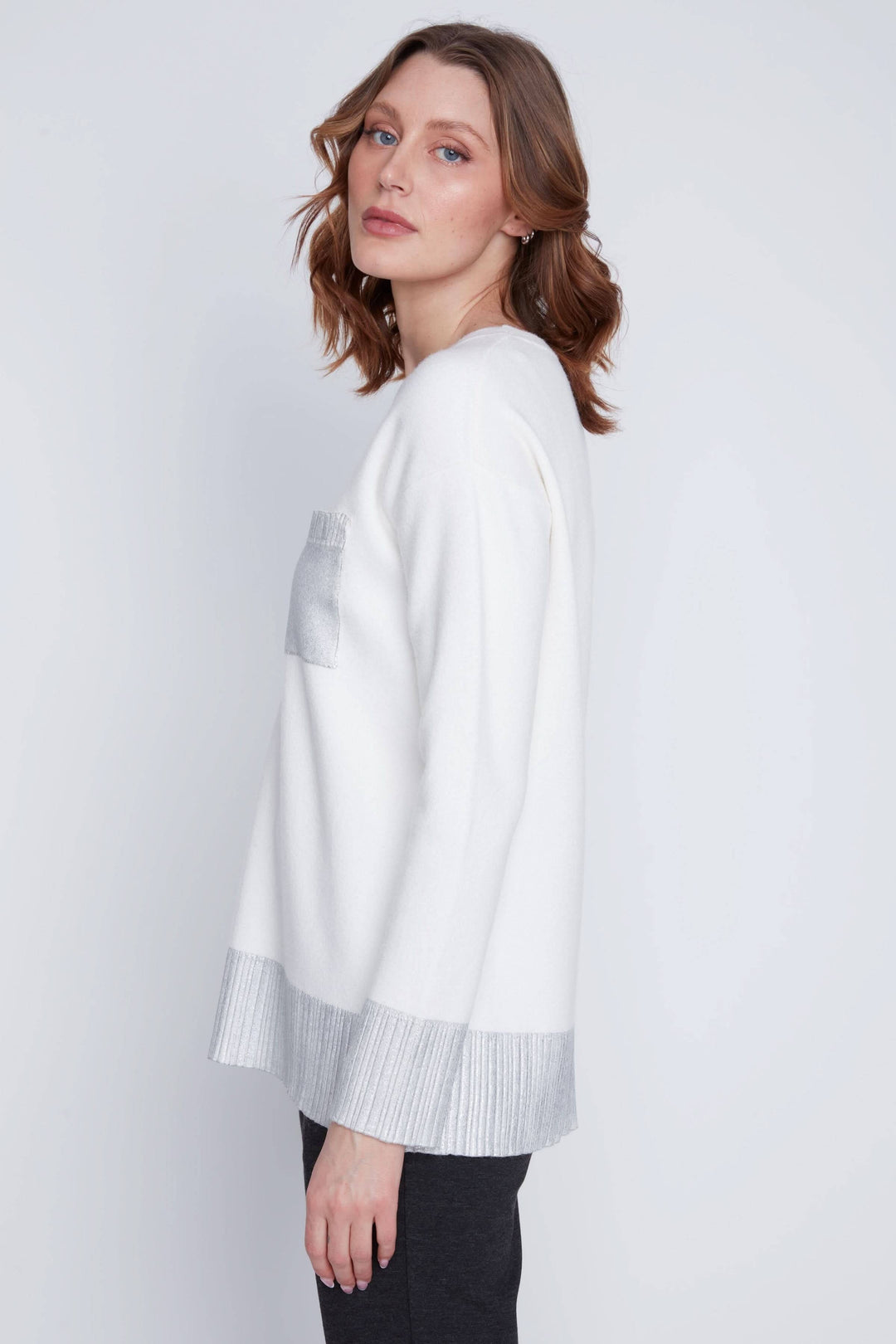 Chandail à manches longues blanc avec détails métallisés sur la poche et aux poignets, coupe droite élégante.