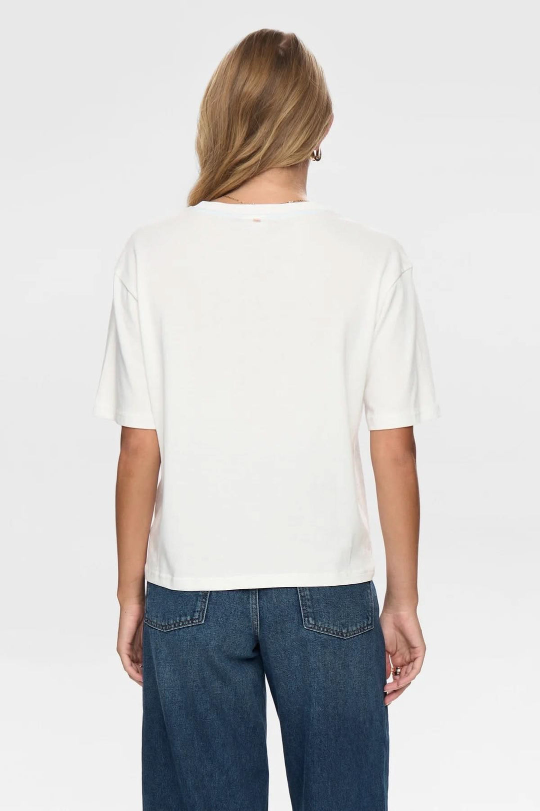 Vue arrière d'un T-shirt à broderies florales avec coupe ample et manches courtes, style minimaliste.