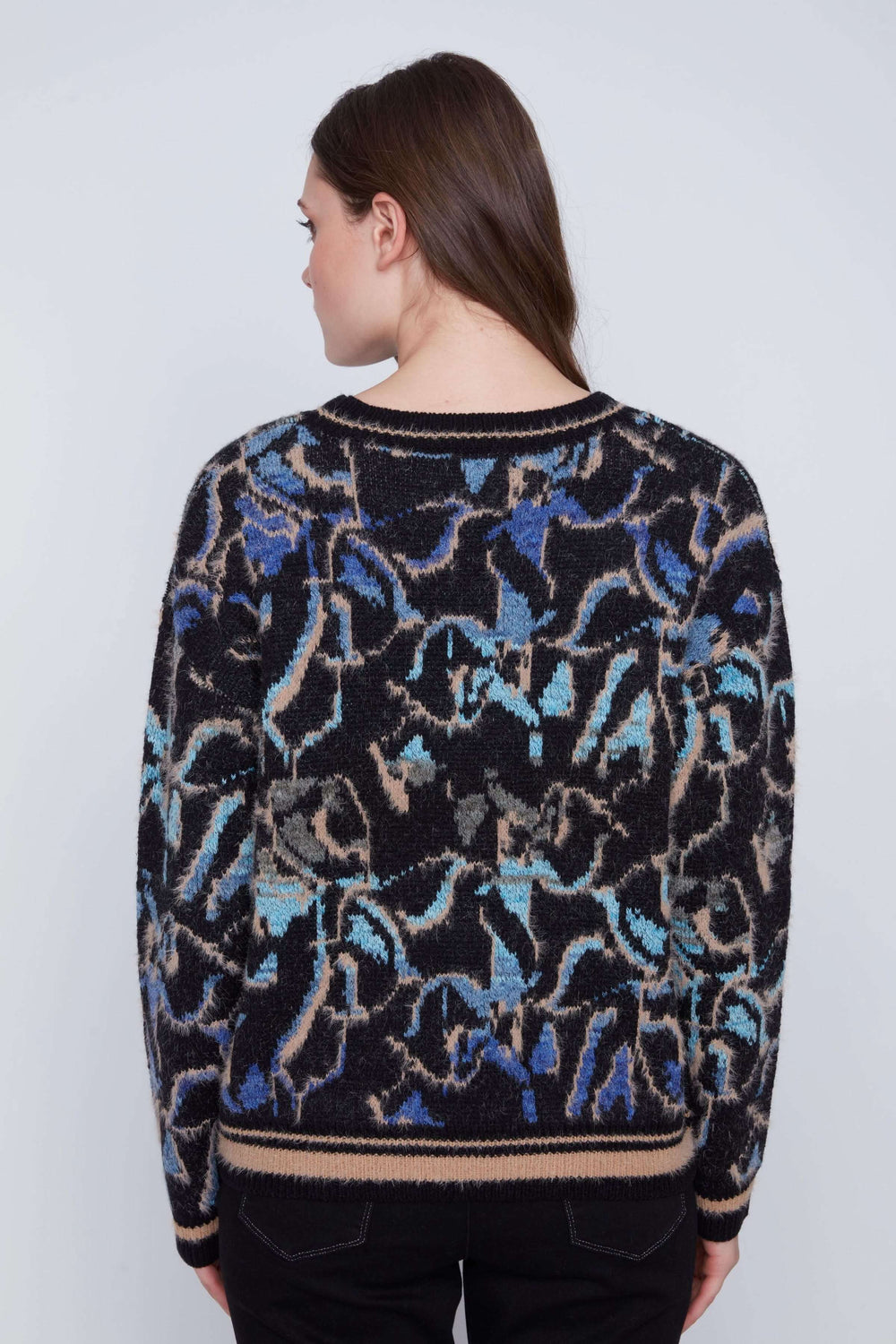 Tricot à manches longues avec motif abstrait coloré, vue de dos sur mannequin, texture douce et finitions côtelées.