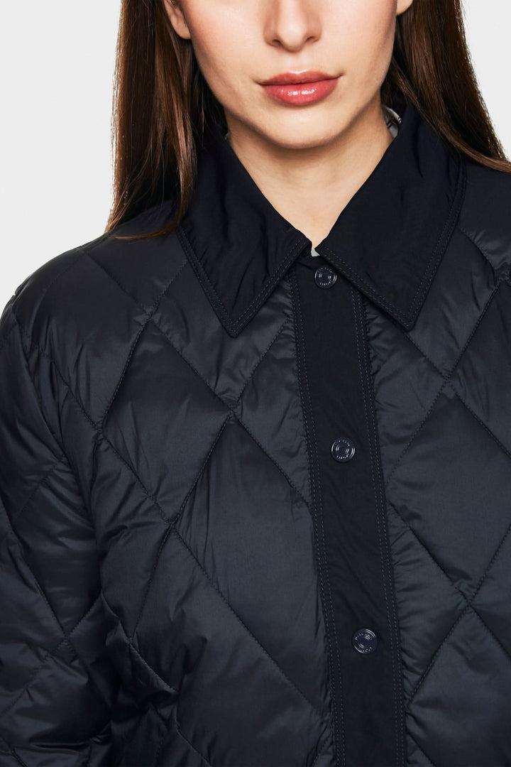 Veste matelassée noire au design épuré, fabriquée en fibres recyclées, label « Rethink Together ».