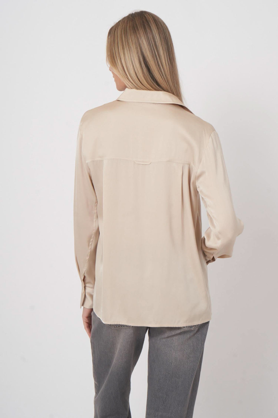 Chemise en soie beige vue arrière, élégante et fluide, parfaite pour un look chic et décontracté.