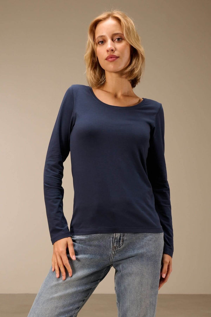 Femme portant un T-shirt manches longues col rond — jersey doux extensible, avec jean, style décontracté.