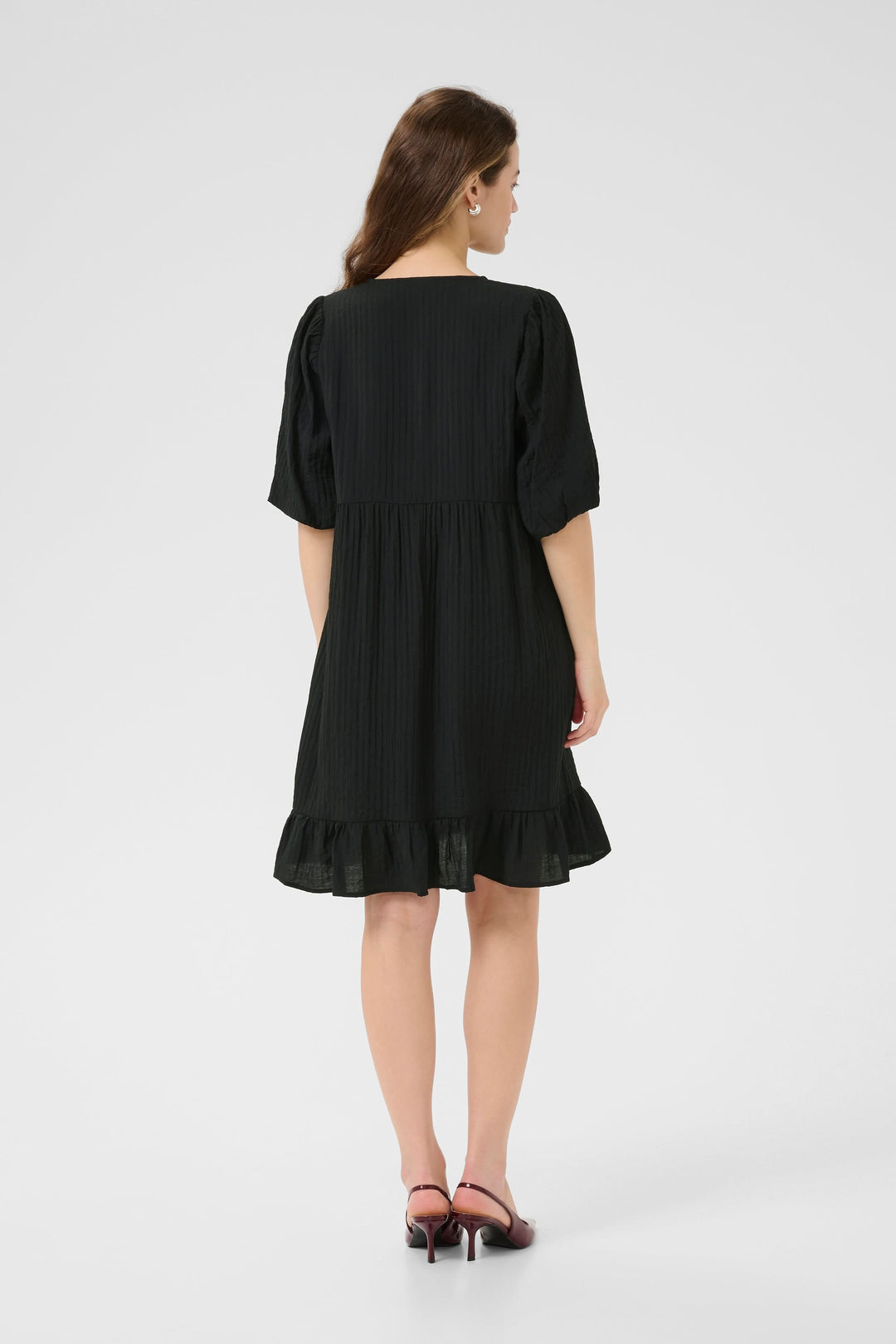 Robe courte Lianna vue de dos, en mousseline noire avec manches bouffantes et bas volanté.