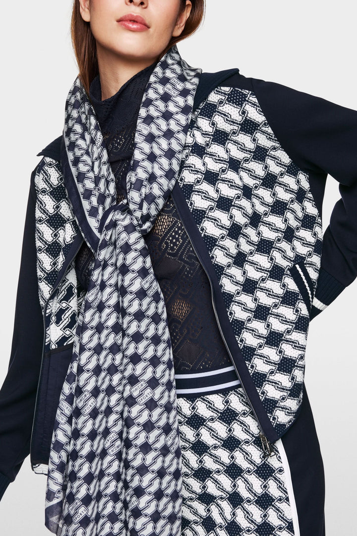 Cardigan en maille graphique zippé, porté avec une écharpe, parfait pour un style décontracté et raffiné.