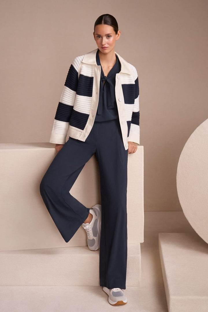 Cardigan court à blocs de couleur avec empiècements en denim, look décontracté et moderne, associé à un pantalon fluide.