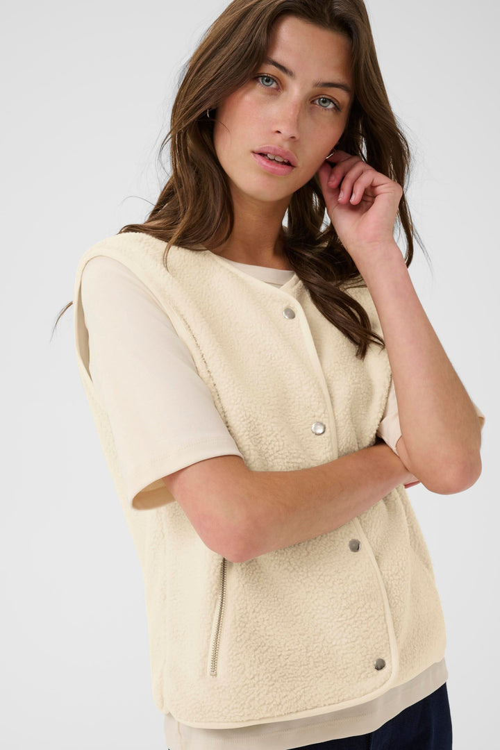 Veste sans manches en tissu sherpa beige, élégante et confortable, idéale pour un look décontracté.