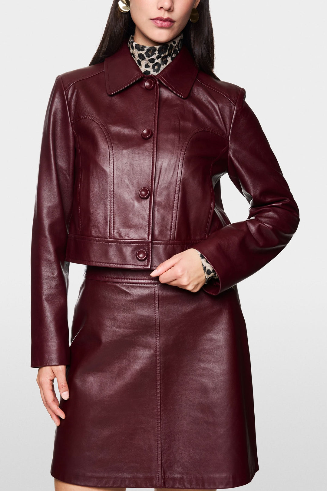 Veste en cuir bordeaux avec coupe courte et structurée, parfaite pour un look chic.