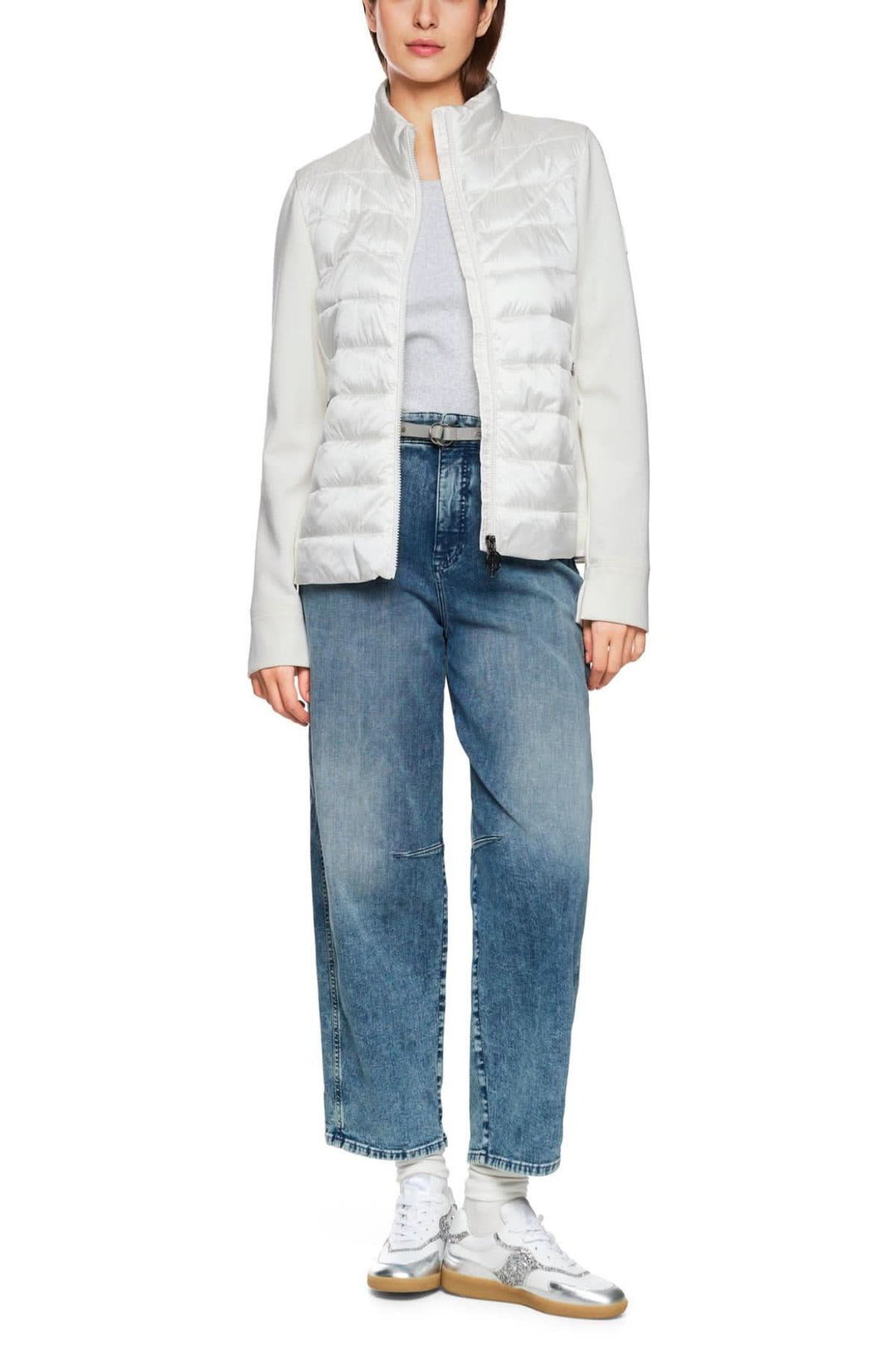 Veste légère matelassée blanche avec manches en viscose, associée à un jean droit, idéale pour l'automne.