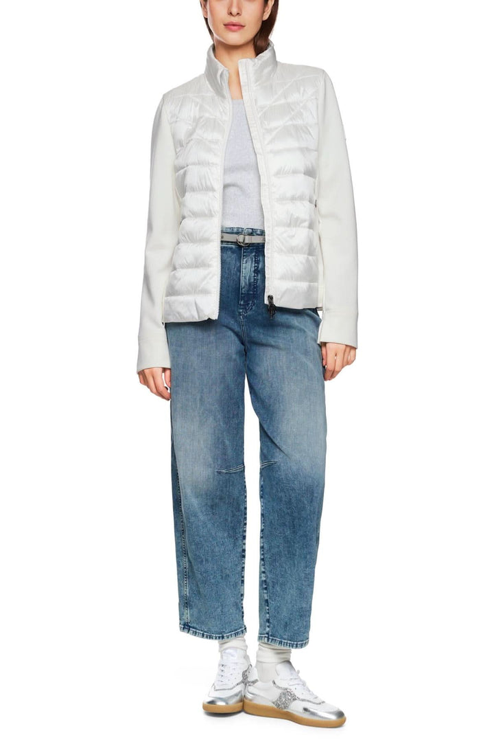 Veste légère matelassée blanche avec manches en viscose, associée à un jean droit, idéale pour l'automne.
