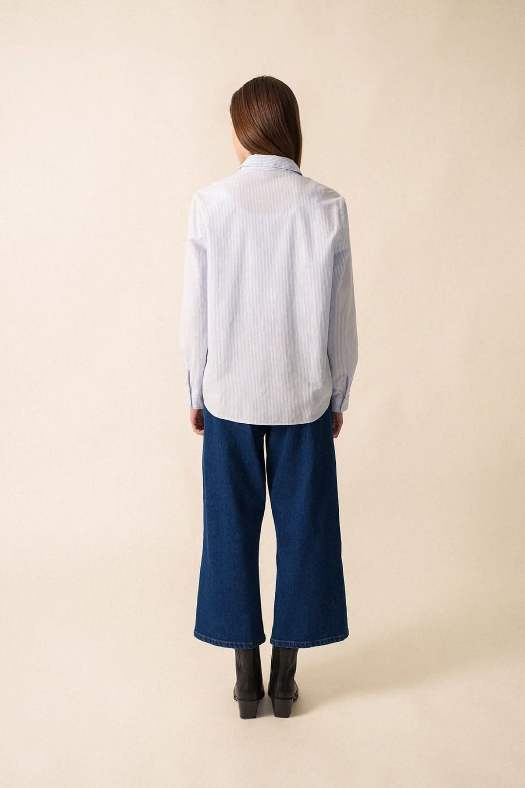 Vue arrière de la chemise rayée Léna en coton, portée avec un pantalon large en denim.