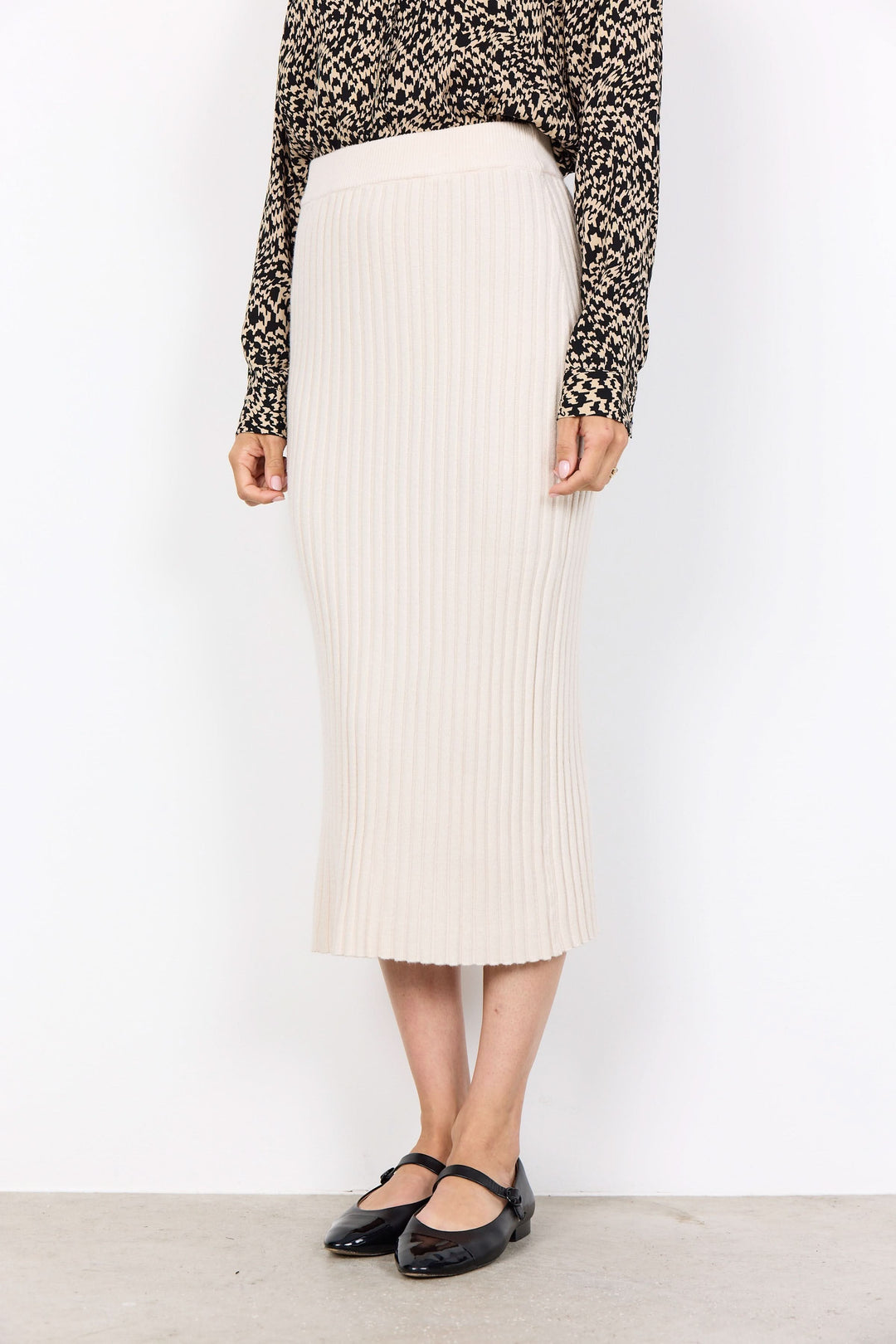 Jupe midi en maille côtelée beige, élégante et confortable, parfaite pour un look moderne et féminin.