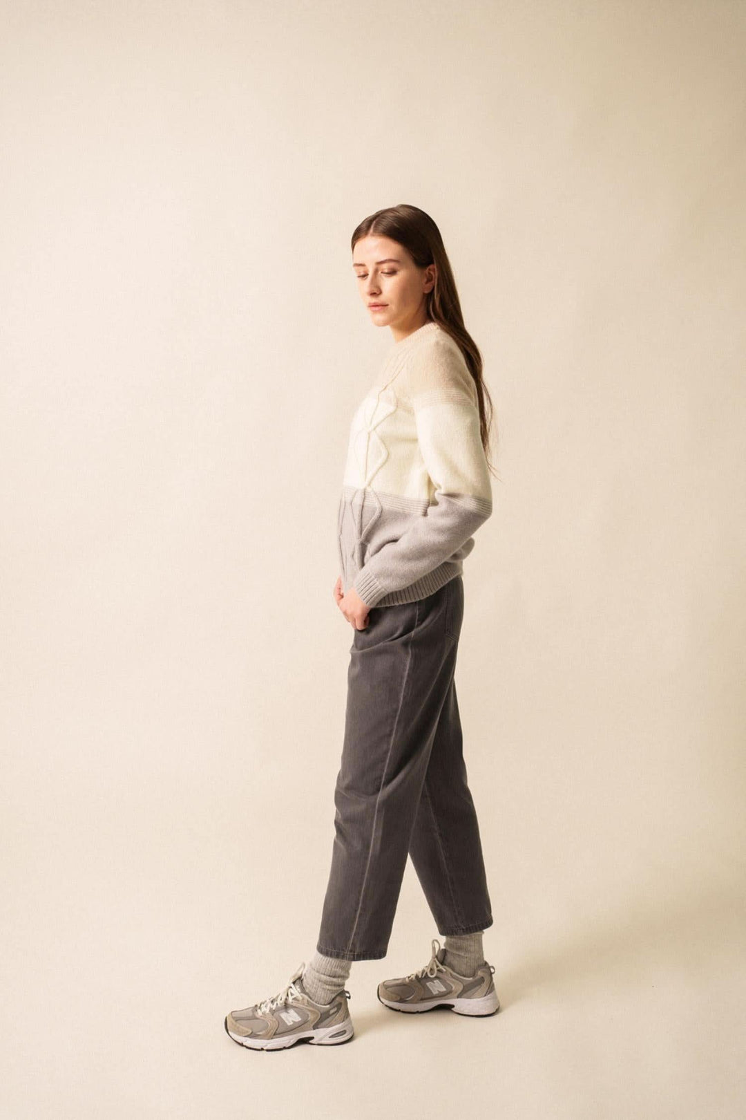 Femme portant un pull en mohair structuré aux teintes grises, associé à un pantalon décontracté et des baskets.