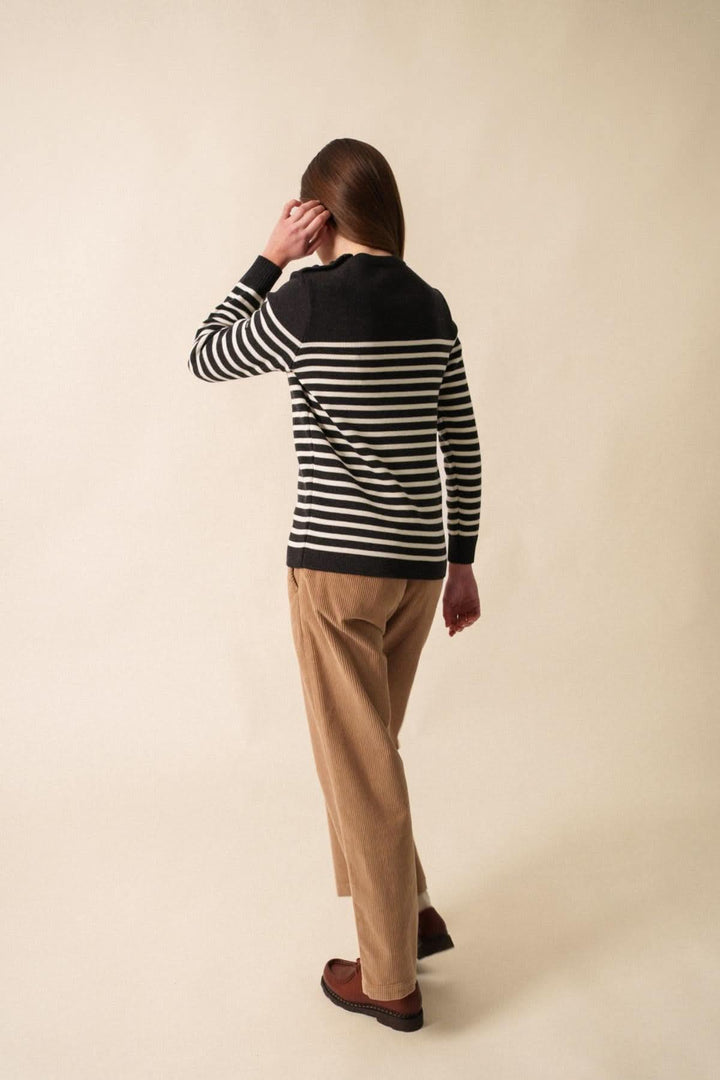 Chandail Rochefort R F en laine mérinos, rayé noir et blanc, porté avec un pantalon beige, vue de dos.