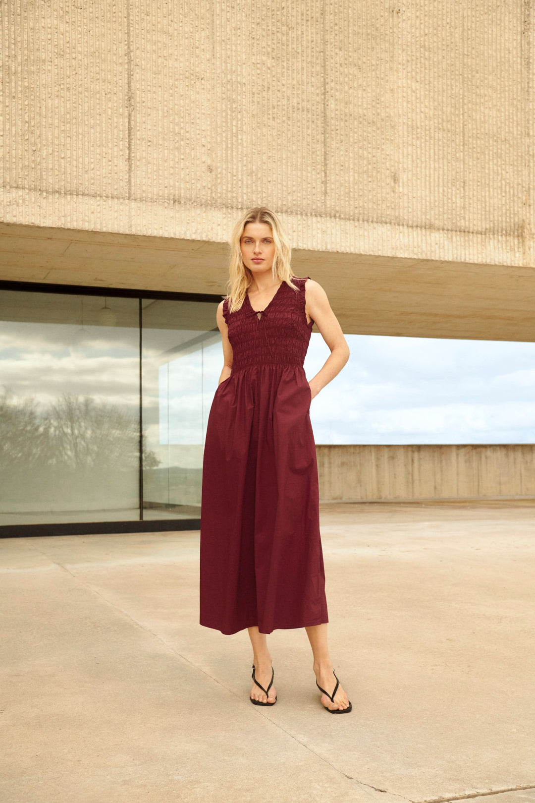 Robe Borgnette longue smockée sans manches avec jupe fluide et encolure en V, parfaite pour un look décontracté ou habillé.