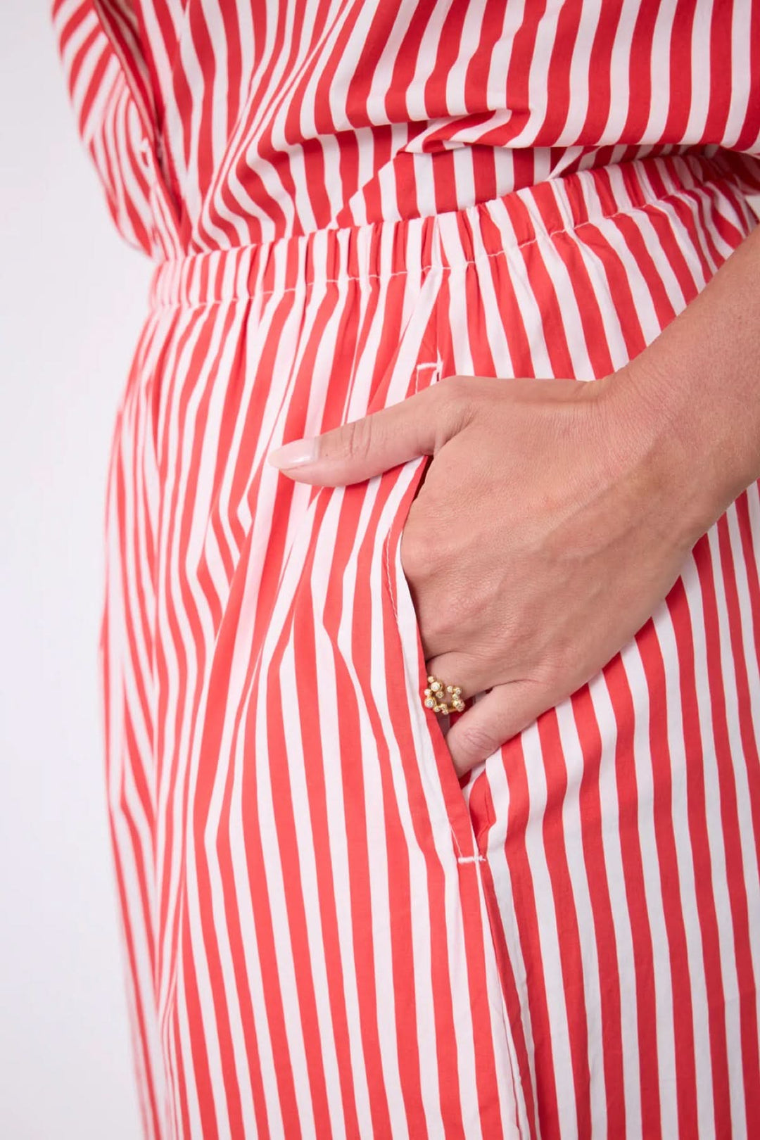 Jupe Ilona longue rayée taille élastique avec détails de fente latérale et poches. Silhouette fluide et élégante pour un look estival.