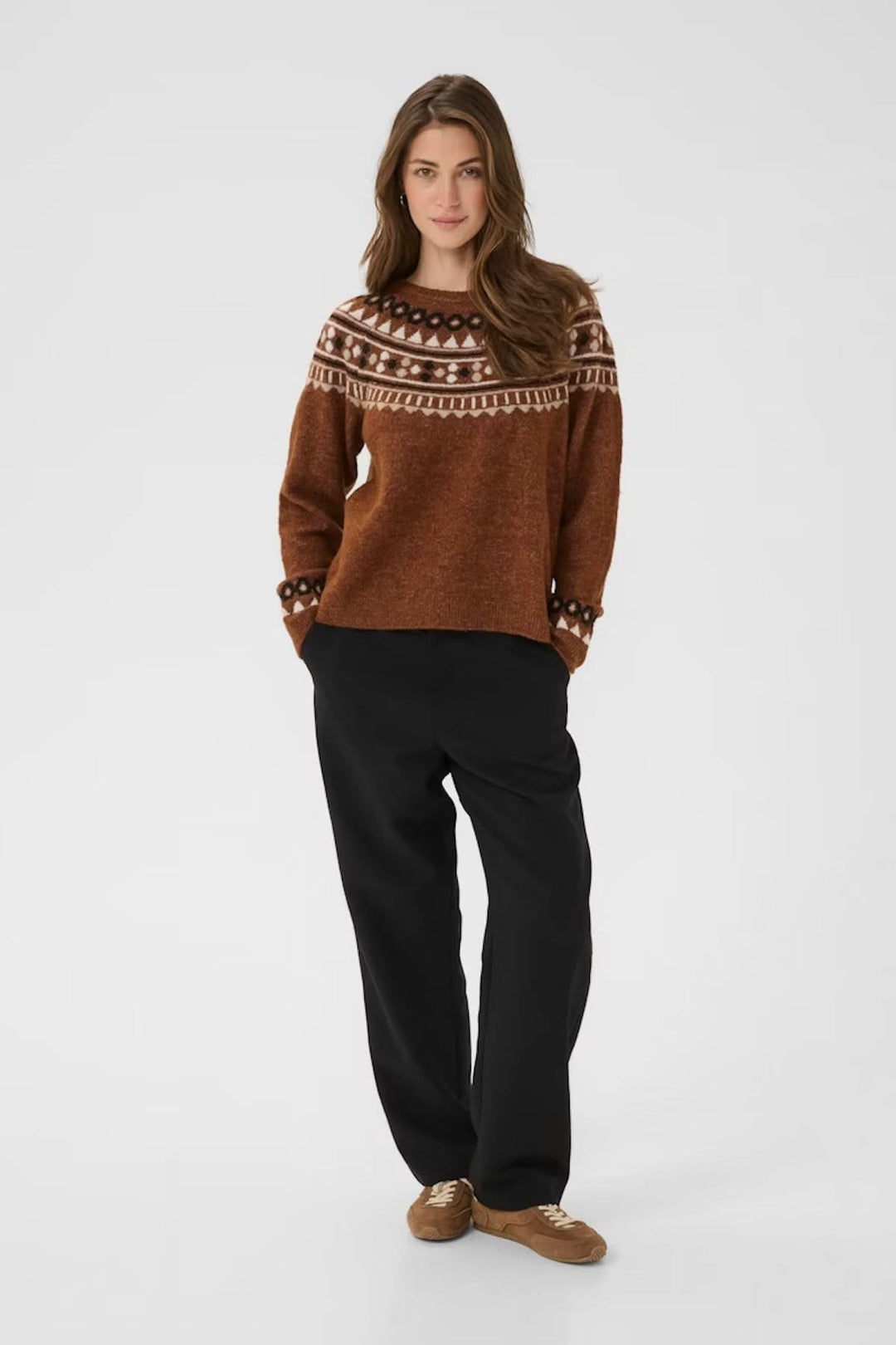 Chandail à motif jacquard nordique en maille douce, porté avec un pantalon noir pour un look hivernal confortable.