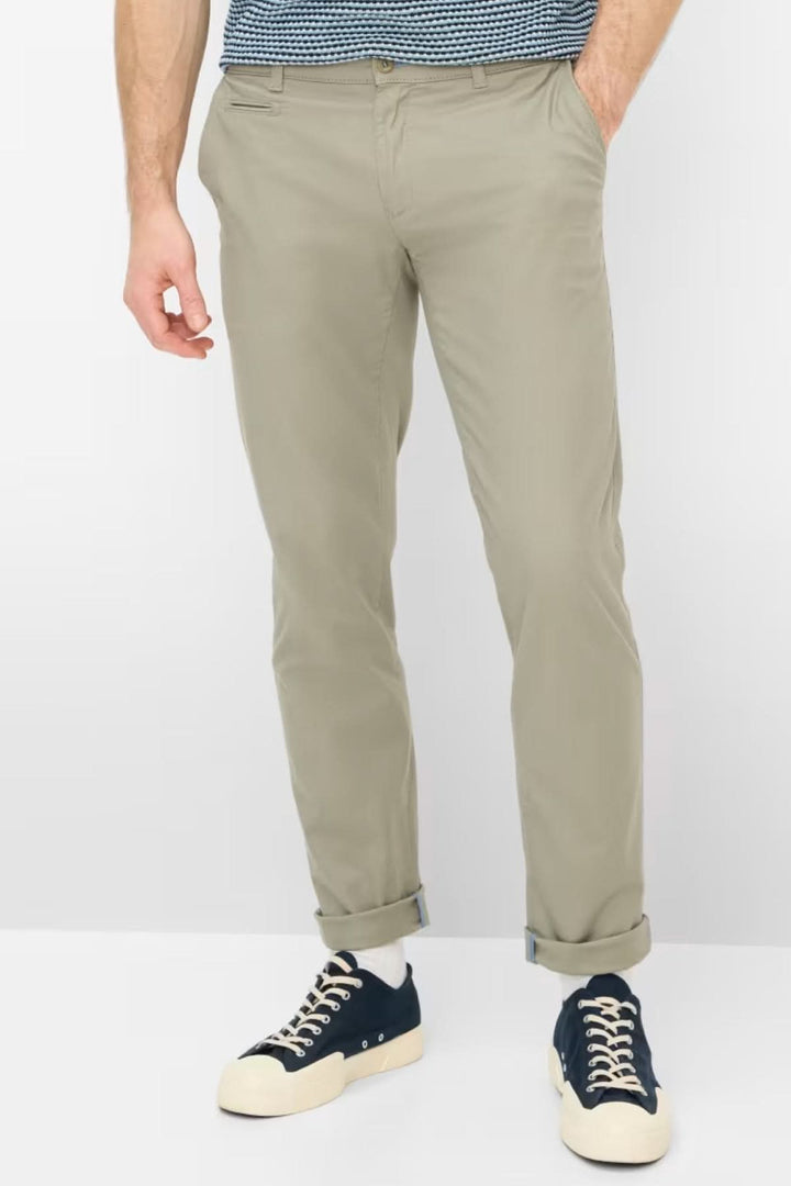 Homme portant un Pantalon style Fabio, coupe droite, longueur cheville, en tissu léger, avec poches et fermeture à bouton et glissière.