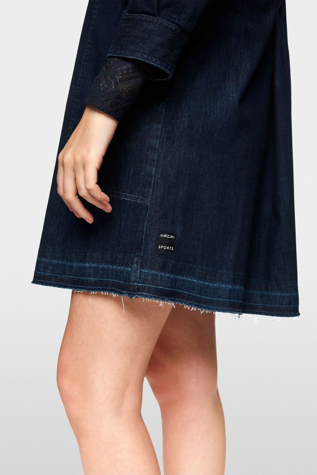 Détail de la robe en jean trapèze, montrant la coupe et le tissu en denim foncé.