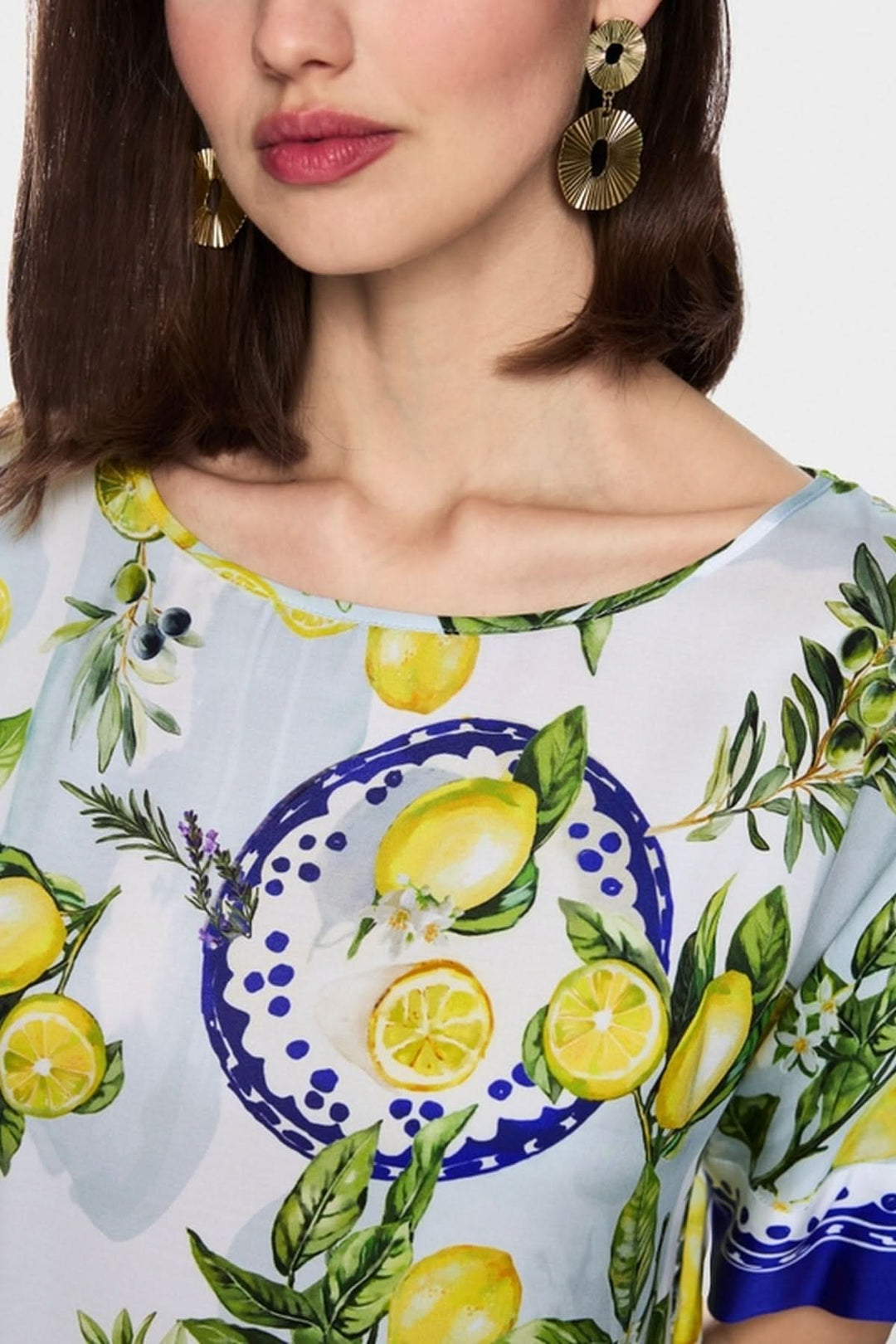 Blouse imprimé méditerranéen avec motifs de citrons et olives, col rond, manches mi-longues, tissu viscose pour un look estival.
