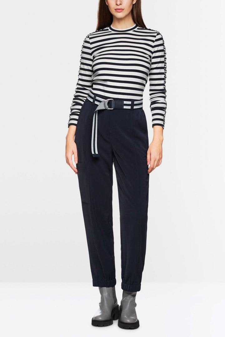Chandail à rayures maritimes avec mini-volants et pantalon noir ceinturé, style moderne et confortable.