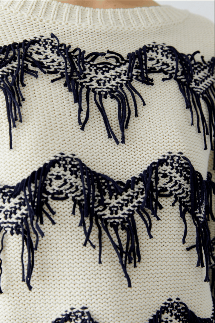 Tricot motif zigzag en pur coton avec franges texturées, coupe carrée et encolure sous-marine.
