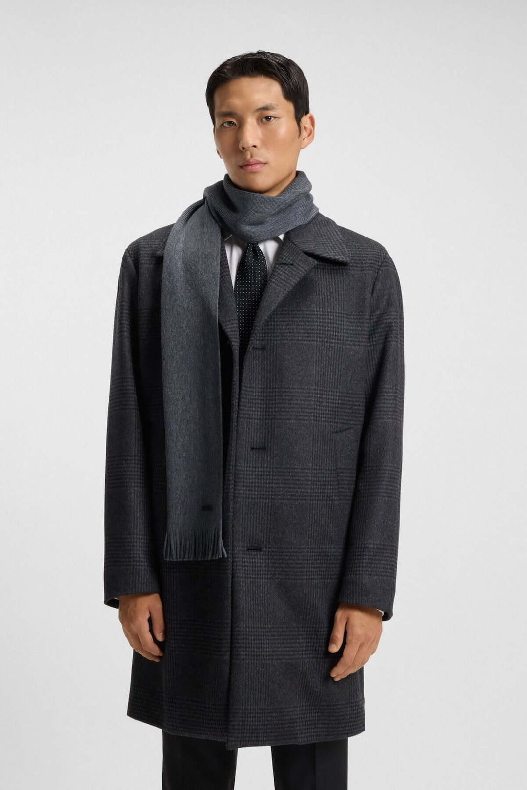 Homme portant un foulard de laine vierge Boss, tricoté en maille Raschel, idéal pour un look hivernal élégant et raffiné.