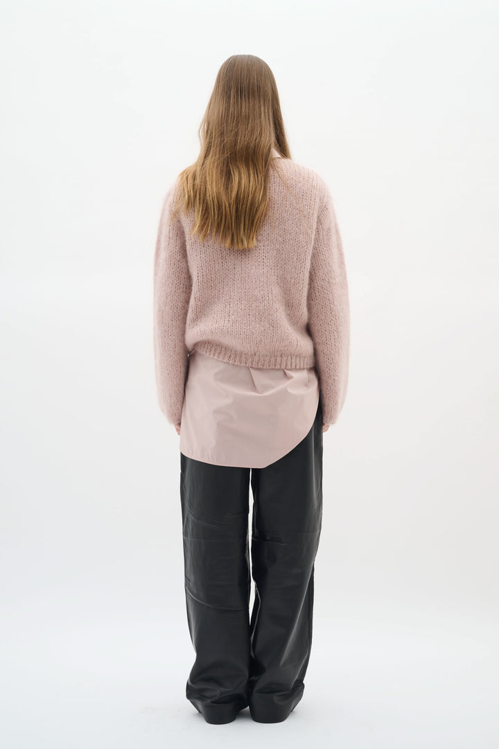 Vue arrière d'un chandail Jetra en maille duveteuse, combiné avec un sous-vêtement de couleur beige et un pantalon noir.