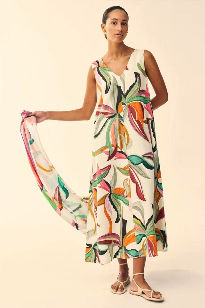 Femme portant une robe longue fluide imprimée à col v avec motif artistique coloré.