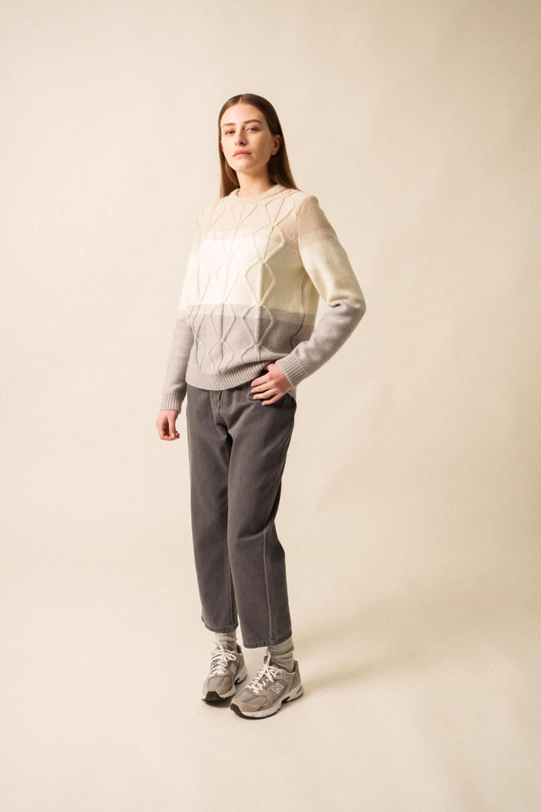 Pull en mohair structuré dégradé de tons, porté avec un pantalon gris, élégant et moderne.