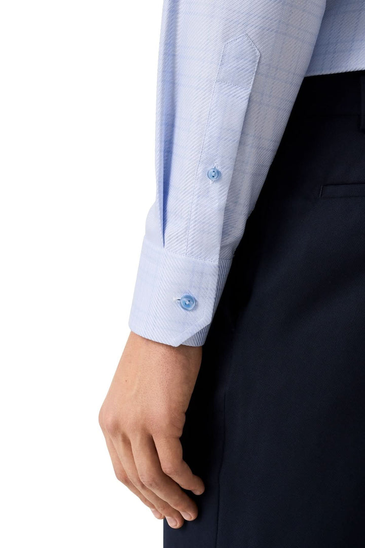 Détail de manche chemise en coton bleu clair à carreaux fins ton sur ton, élégance moderne pour occasions professionnelles.