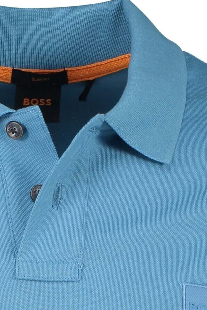 Polo bleu BOSS avec col classique, finitions ton sur ton et détail orange à l'intérieur du col.