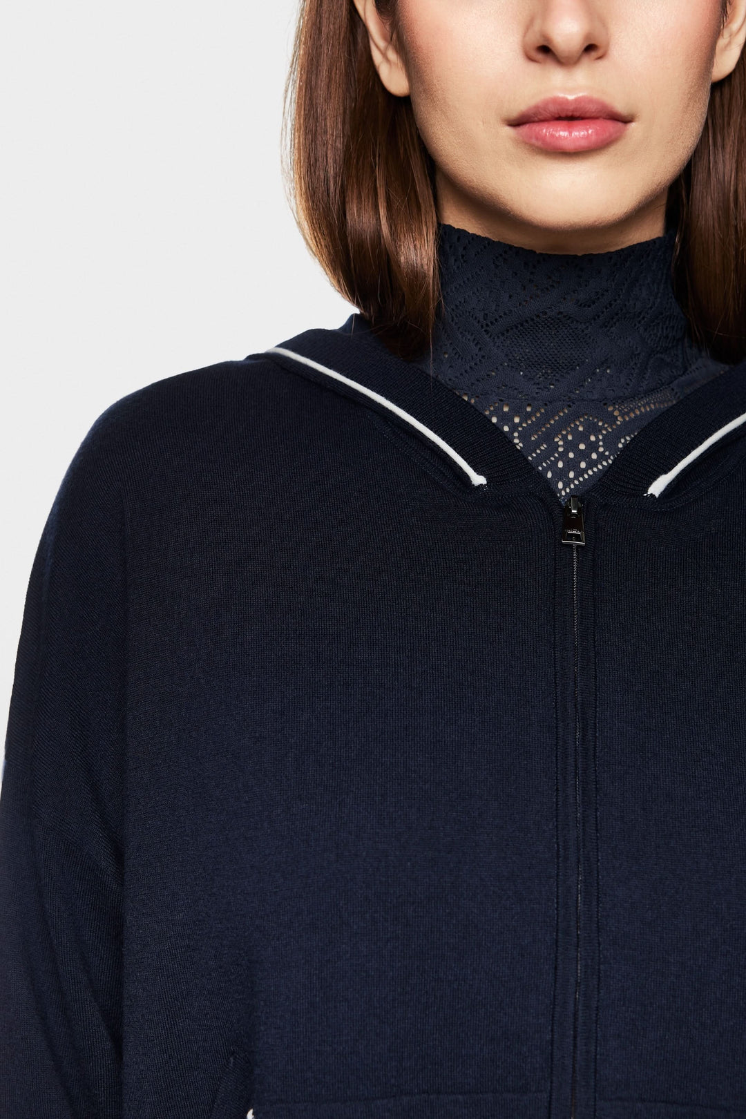 Cardigan tricoté avec capuchon zippé, détails contrastants et style décontracté, parfait pour une allure cosy-chic.
