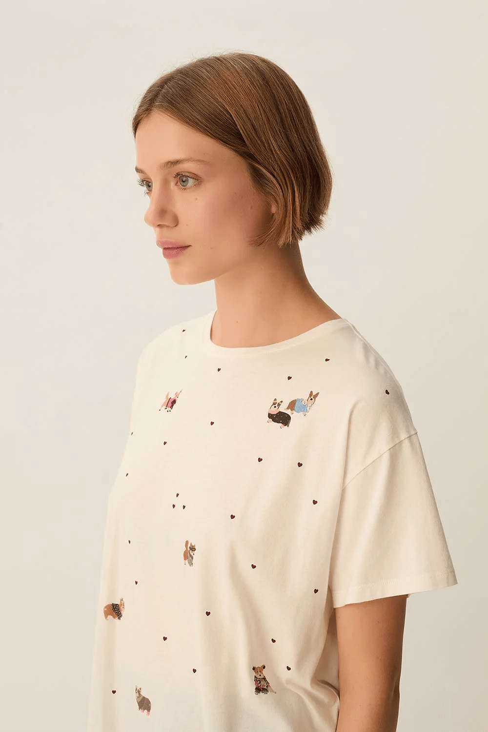 Femme portant un T-shirt Fanelie ample imprimé chiens avec motifs cœurs, idéal pour un look décontracté.