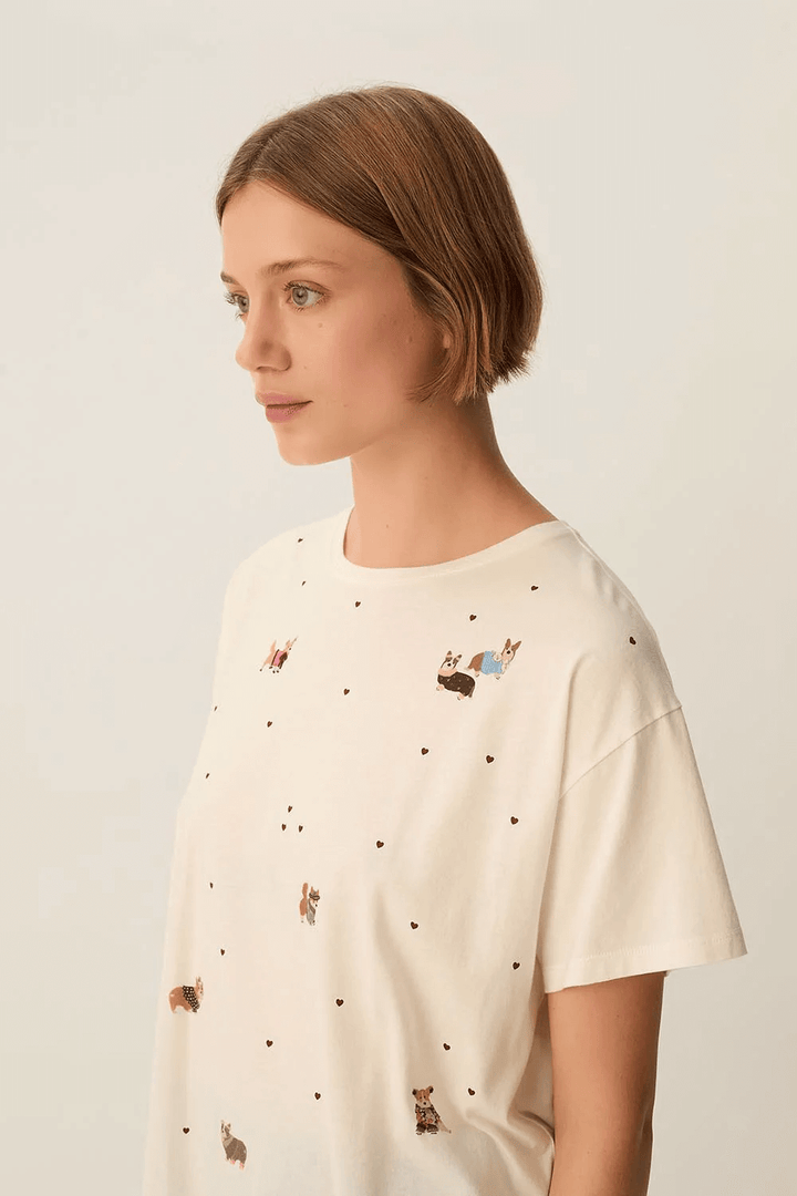 Femme portant un T-shirt Fanelie ample imprimé chiens avec motifs cœurs, idéal pour un look décontracté.