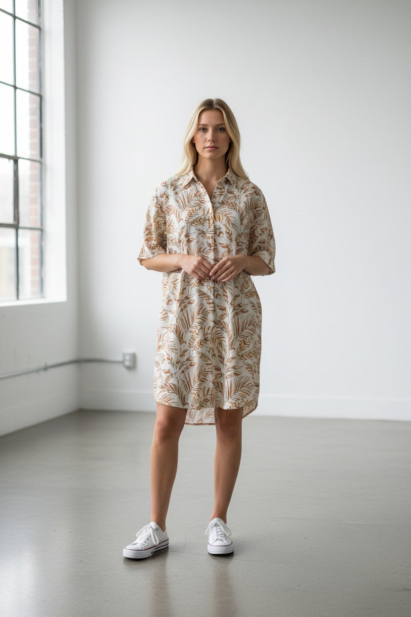 Robe imprimée LEONIE: robe courte avec silhouette fluide, idéale pour les journées ensoleillées, portée par une femme dans un intérieur spacieux.
