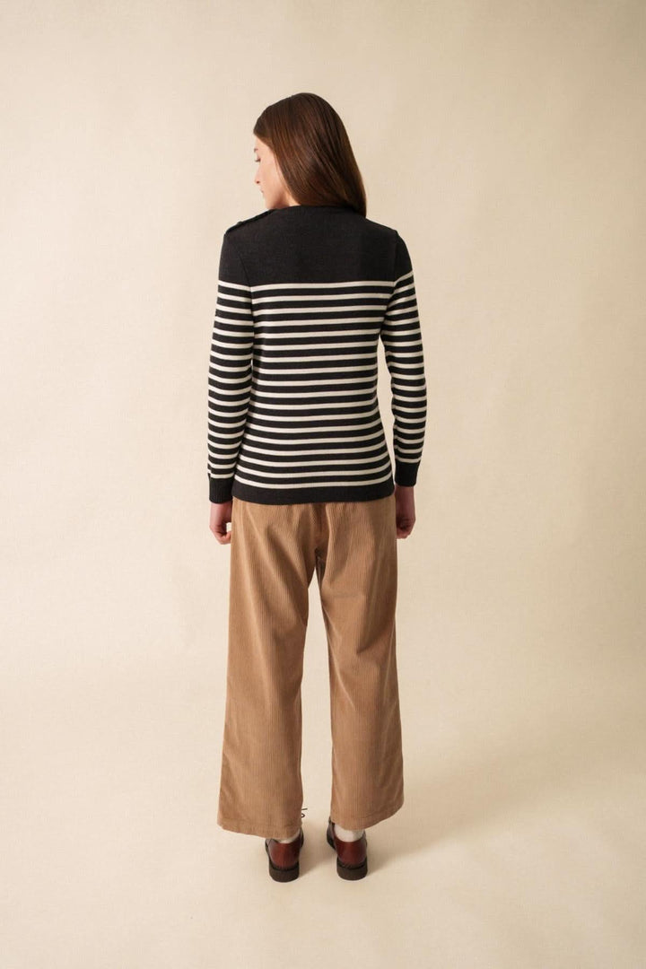 Chandail Rochefort en laine mérinos, rayé noir et blanc, porté avec un pantalon beige, vue de dos.