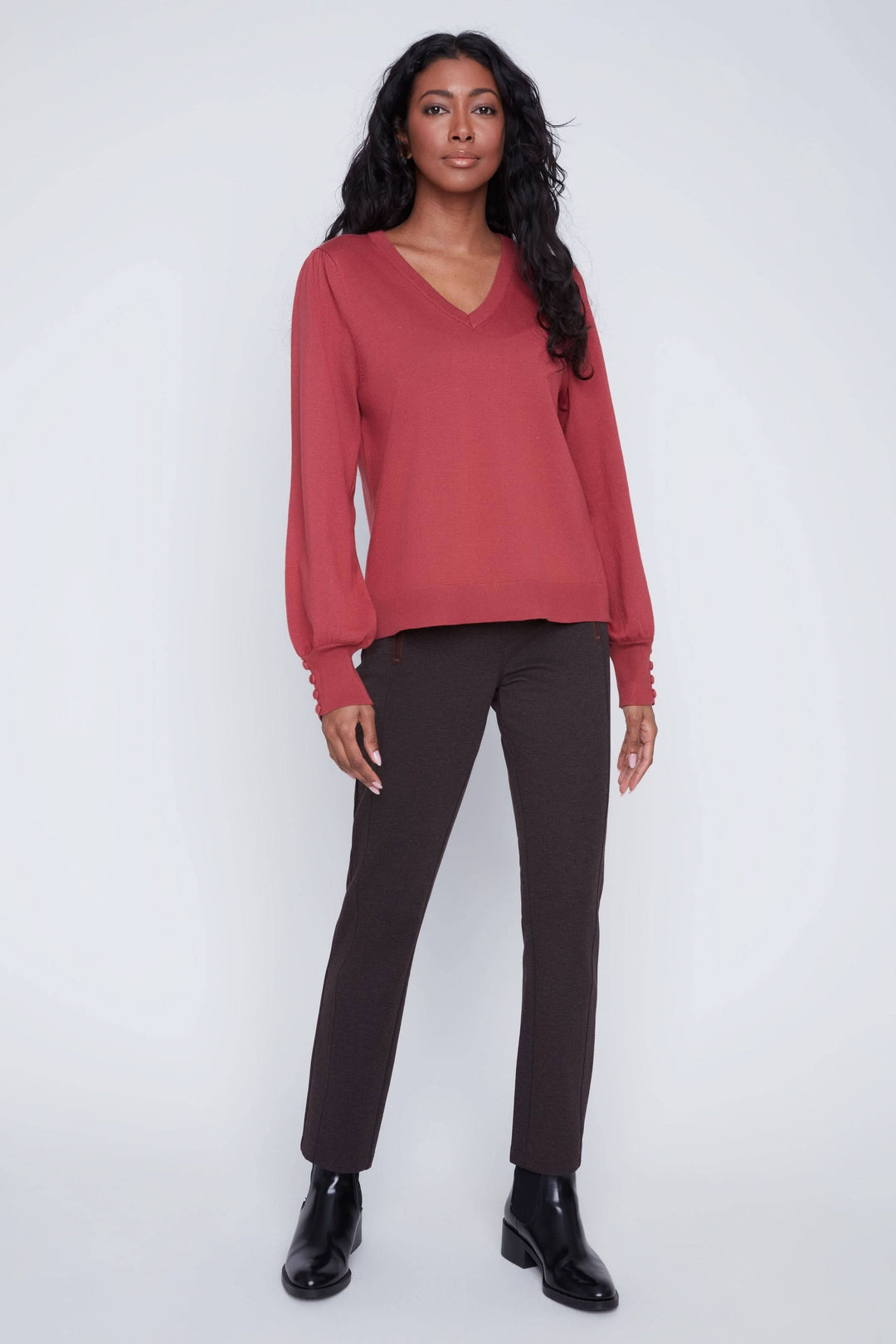 Chandail encolure en V à manches bouffantes, porté avec un pantalon ajusté, style élégant et confortable.