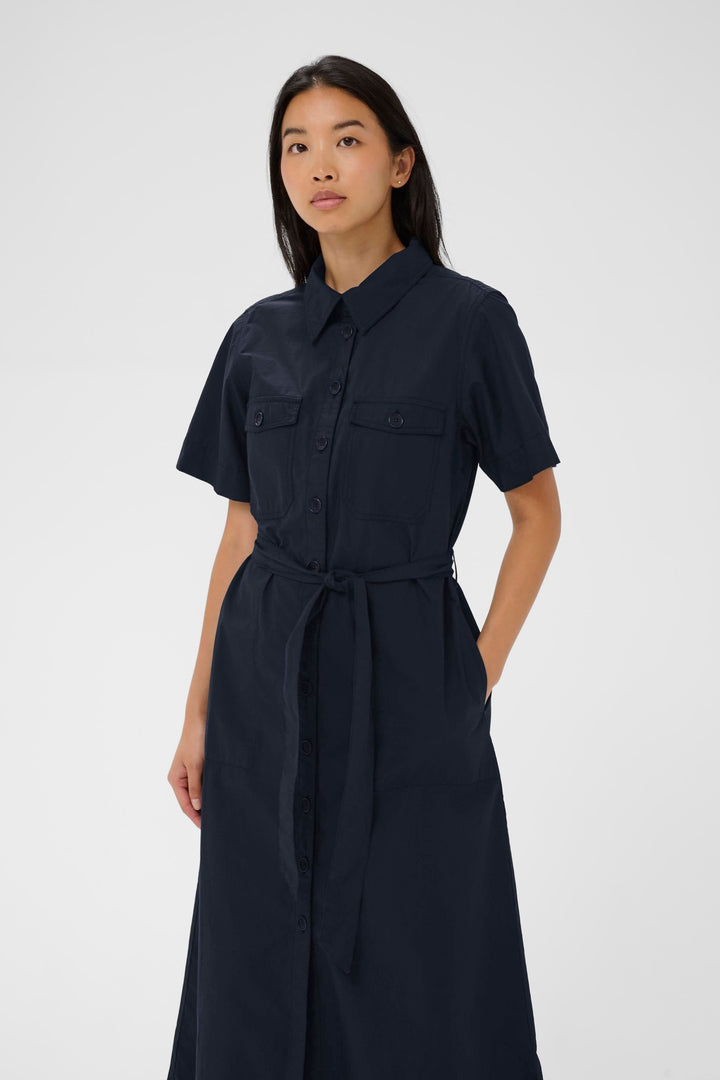 Robe Ariel chemise longue ceinturée manches courtes en tissu confortable avec ceinture à nouer et poches poitrine à rabat.