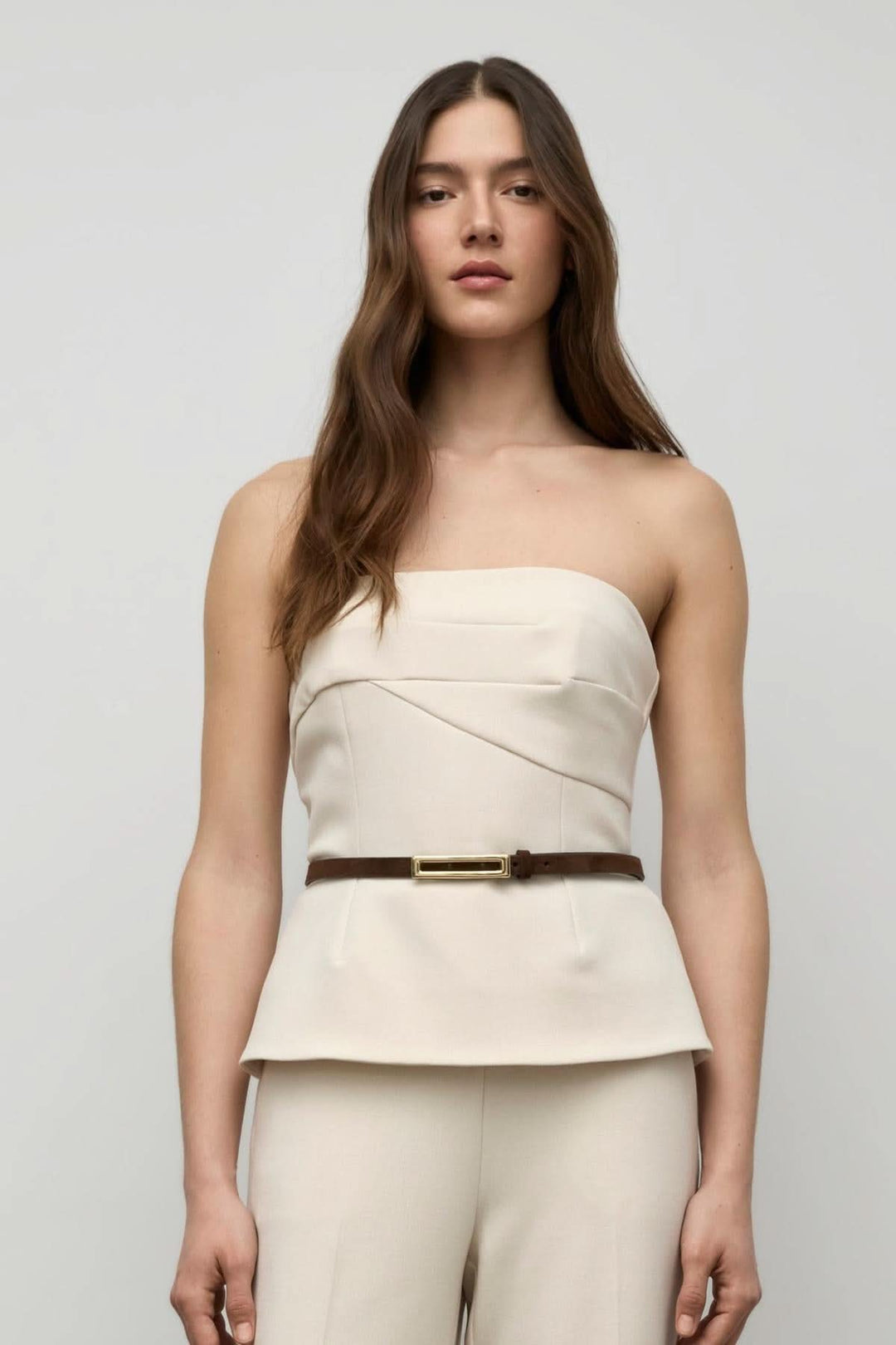 Bustier haut structuré avec bretelles amovibles, plissé délicat, porté avec un pantalon habillé.