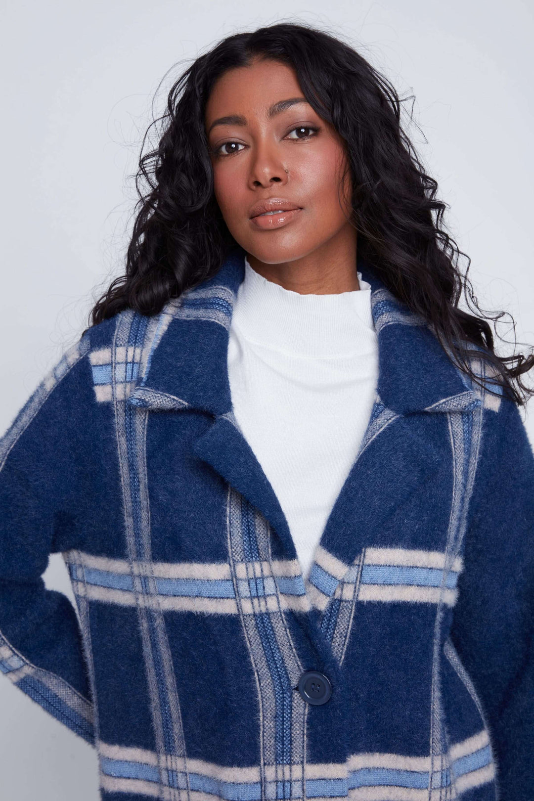 Manteau long à carreaux bleu pour femme, col à revers et fermeture à bouton unique, style chic et moderne.