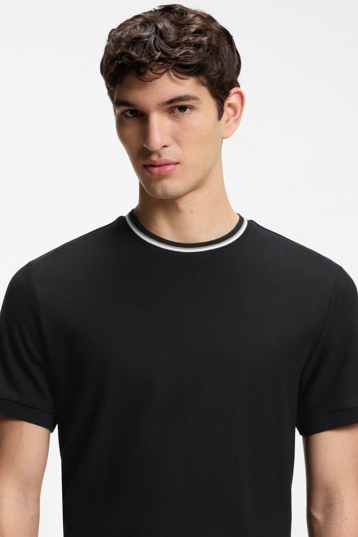 Homme portant un T-shirt à encolure contrastée avec manches courtes et finition soignée, idéal pour un look moderne et décontracté.