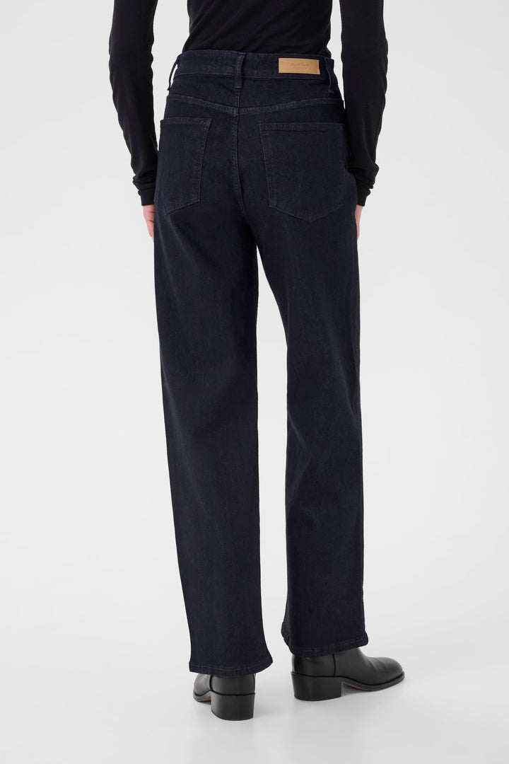 Jean Simona à jambe droite, vue arrière, taille mi-haute, coupe ample, denim noir élégant.