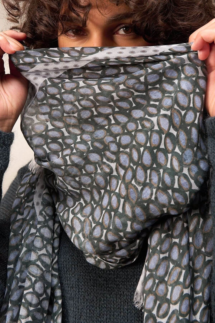 Foulard imprimé léger porté, texture douce et sophistiquée. Parfait pour une touche élégante avec un chandail uni.