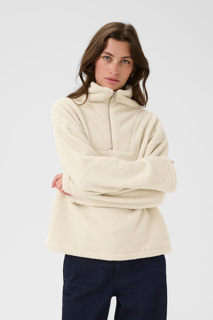 Chandail Sirana en tissu effet sherpa, col montant zippé, coupe décontractée, couleur crème.