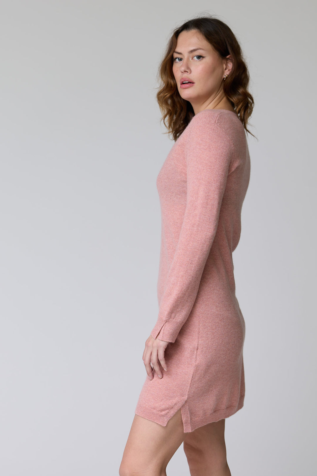 Robe Bonnie en tricot à col en V rose, manches longues, coupe droite féminine et élégante, vue de profil, porter avec bottes ou plats.