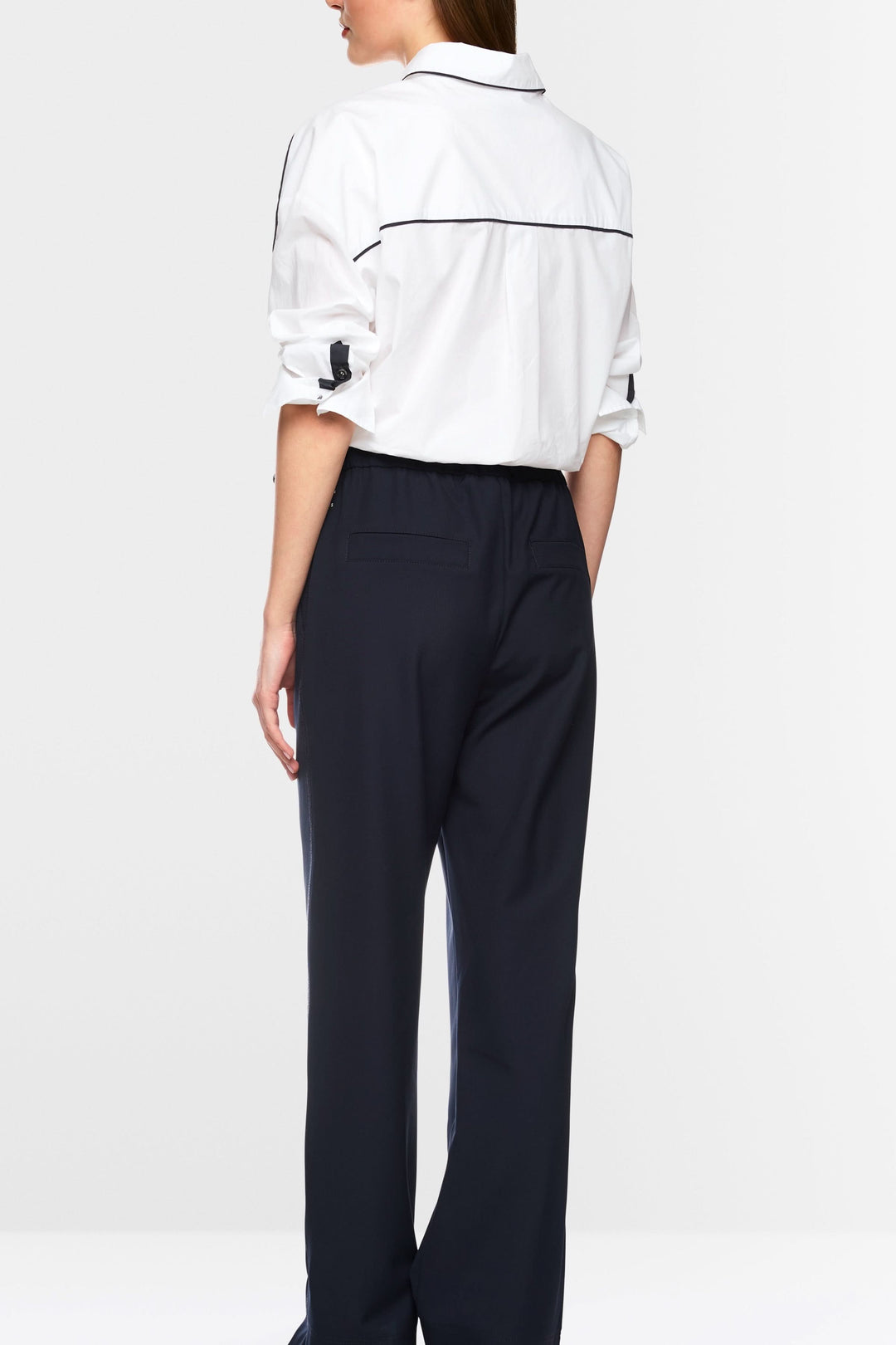 Vue arrière d'une chemise courte blanche avec détails contrastants et pantalon noir ample, style moderne et sportif.