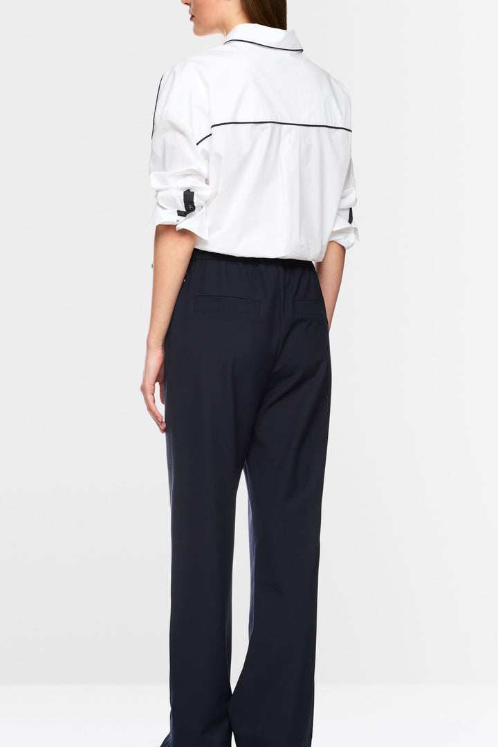 Vue arrière d'une chemise courte blanche avec détails contrastants et pantalon noir ample, style moderne et sportif.