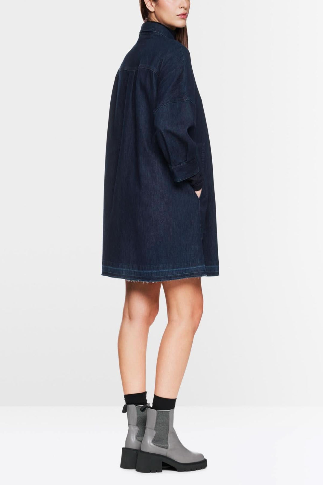 Robe en jean trapèze avec manches bouffantes, portée avec des bottines, vue arrière.