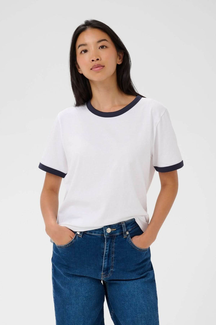 Femme portant un T-shirt à col contrastant Angelita avec finitions modernes et coupe droite, assurant confort et style décontracté.